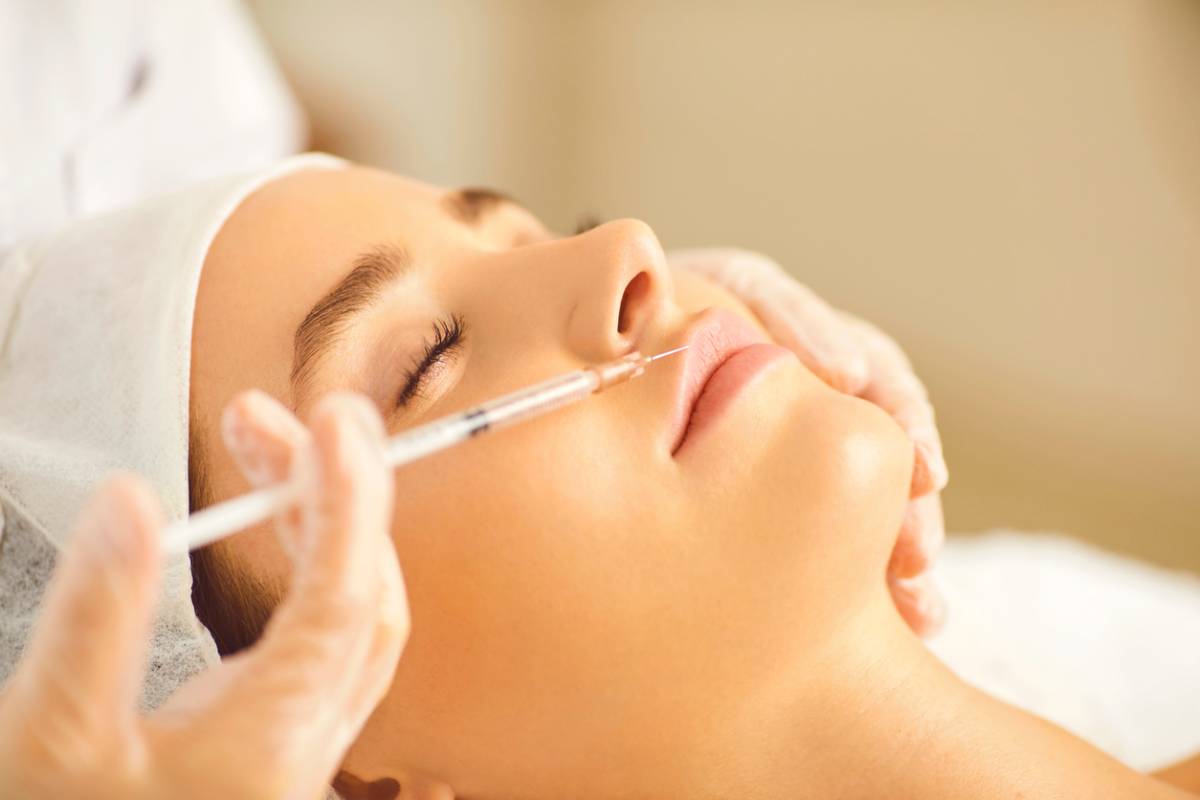 Cosmetologist makes beauty injections in the woman's lip